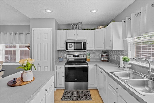 2980 Cool Breeze Cir, Saint Cloud, FL 34769 - kitchen with appliances with stainless steel finishes, a textured ceiling, white cabinets, light countertops, and decorative backsplash