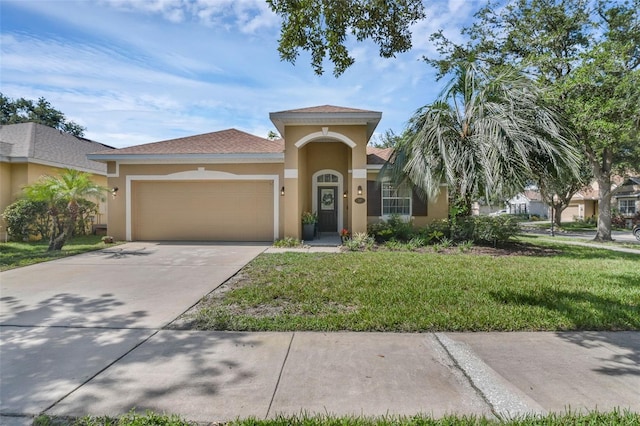 215 Foxglove Way, Deland, FL 32724 - mediterranean / spanish house featuring stucco siding, a garage, a front yard, and concrete driveway