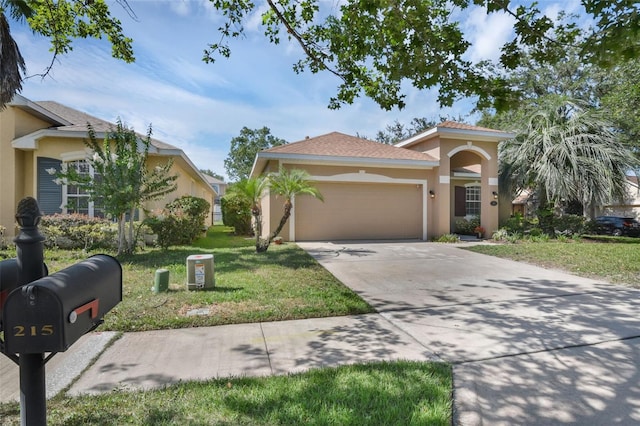 215 Foxglove Way, Deland, FL 32724 - view of front of house with stucco siding, a garage, a front yard, and driveway