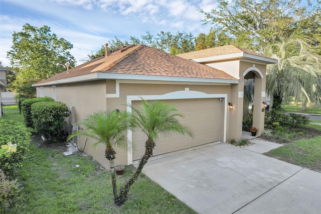 215 Foxglove Way, Deland, FL 32724 - view of property exterior with stucco siding, roof with shingles, driveway, and an attached garage
