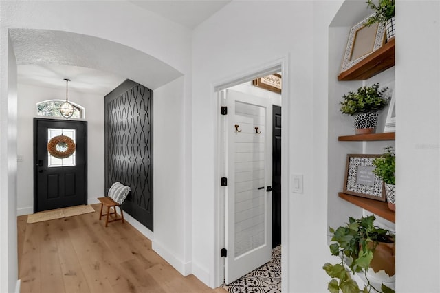 215 Foxglove Way, Deland, FL 32724 - foyer entrance with light wood-style flooring and arched walkways