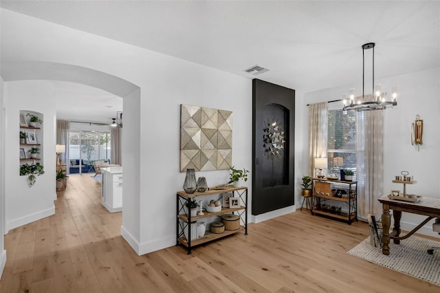 215 Foxglove Way, Deland, FL 32724 - entryway with arched walkways, light wood finished floors, and a chandelier
