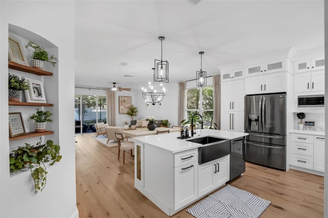 215 Foxglove Way, Deland, FL 32724 - kitchen with stainless steel fridge, dishwashing machine, light countertops, light wood finished floors, and white cabinets