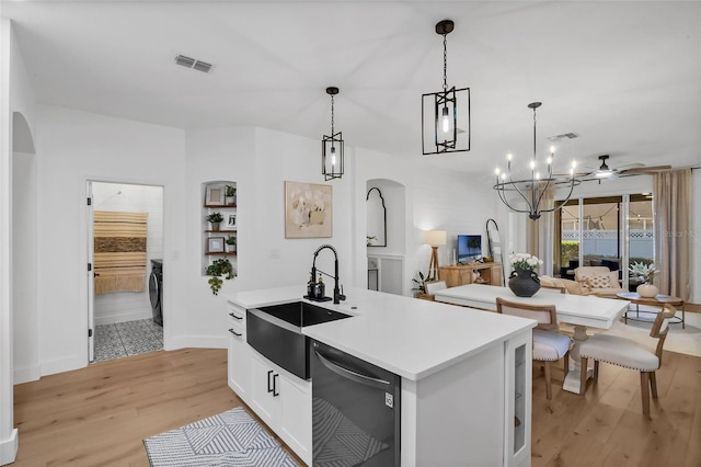 215 Foxglove Way, Deland, FL 32724 - kitchen featuring dishwasher, arched walkways, open floor plan, light wood-style floors, and a kitchen island with sink