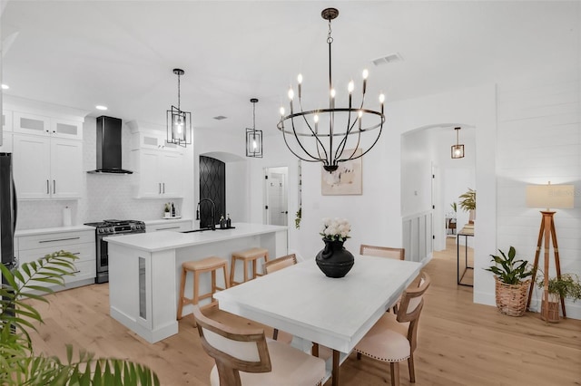215 Foxglove Way, Deland, FL 32724 - dining area with arched walkways, light wood-type flooring, recessed lighting, and a chandelier