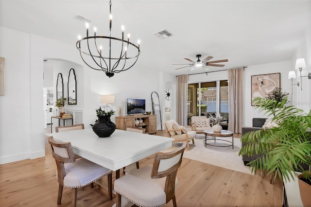 215 Foxglove Way, Deland, FL 32724 - dining area with light wood-style floors, a ceiling fan, a chandelier, and arched walkways