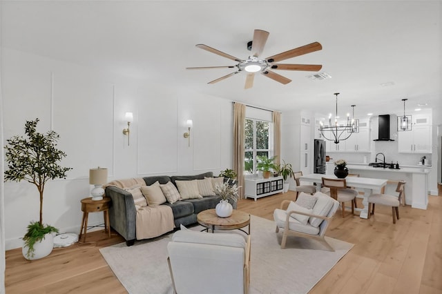 215 Foxglove Way, Deland, FL 32724 - living room with a ceiling fan, a chandelier, and light wood finished floors