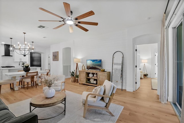 215 Foxglove Way, Deland, FL 32724 - living room featuring light wood-style flooring, a ceiling fan, and arched walkways