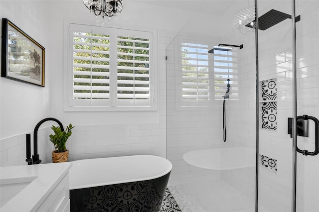 215 Foxglove Way, Deland, FL 32724 - bathroom with a freestanding bath, a stall shower, vanity, a chandelier, and tile walls