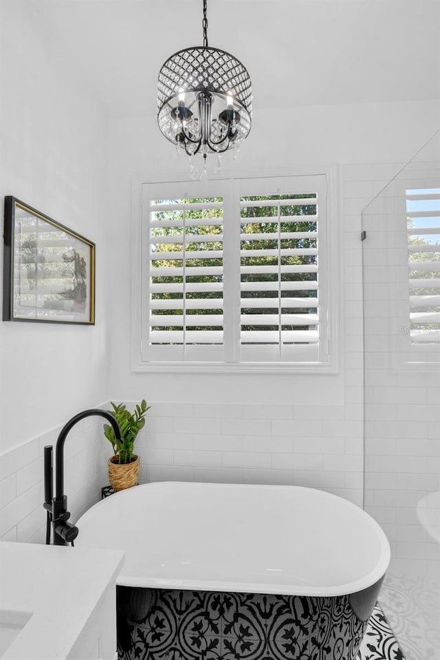 215 Foxglove Way, Deland, FL 32724 - bathroom featuring a chandelier, a freestanding tub, tile walls, and vanity