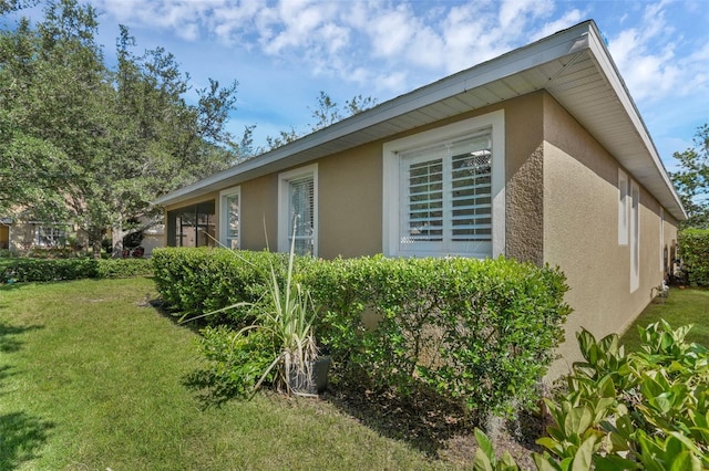 215 Foxglove Way, Deland, FL 32724 - view of side of property featuring stucco siding and a yard