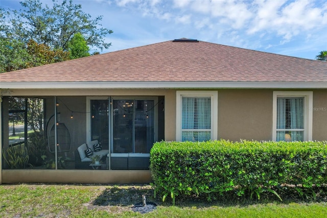 215 Foxglove Way, Deland, FL 32724 - rear view of house with a shingled roof, stucco siding, and a sunroom