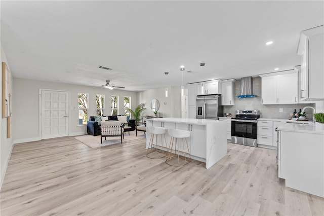 2075 Abalone Ave, Indialantic, FL 32903 - kitchen with stainless steel appliances, wall chimney exhaust hood, open floor plan, light countertops, and a kitchen island