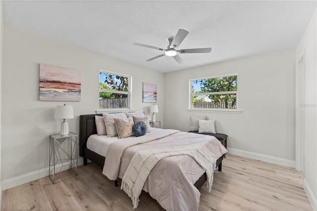 2075 Abalone Ave, Indialantic, FL 32903 - bedroom with multiple windows, light wood-style flooring, a textured ceiling, and a ceiling fan