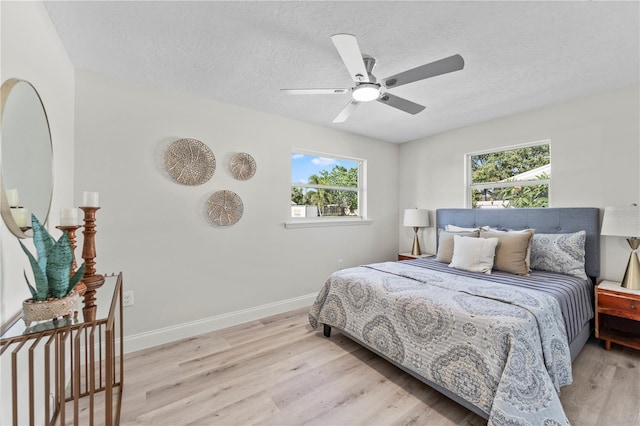 2075 Abalone Ave, Indialantic, FL 32903 - bedroom with light wood finished floors, a textured ceiling, and ceiling fan