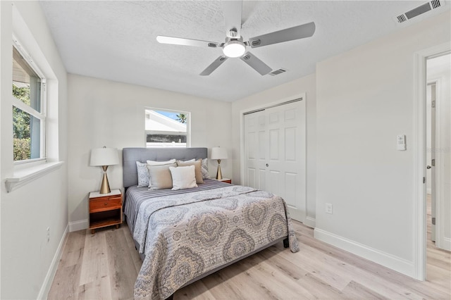 2075 Abalone Ave, Indialantic, FL 32903 - bedroom with light wood-style flooring, a closet, a textured ceiling, and a ceiling fan