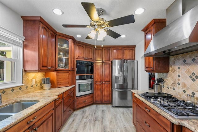 4230 Havana Dr, Cocoa, FL 32927 - kitchen featuring stainless steel appliances, wall chimney range hood, light stone countertops, tasteful backsplash, and light wood finished floors