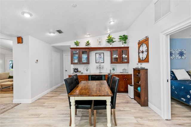 4230 Havana Dr, Cocoa, FL 32927 - dining room with lofted ceiling, light wood-style flooring, and a textured ceiling