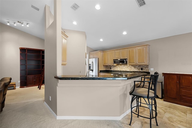 871 Paddington Ter, Lake Mary, FL 32746 - kitchen featuring stainless steel appliances, a peninsula, a kitchen bar, backsplash, and dark stone countertops