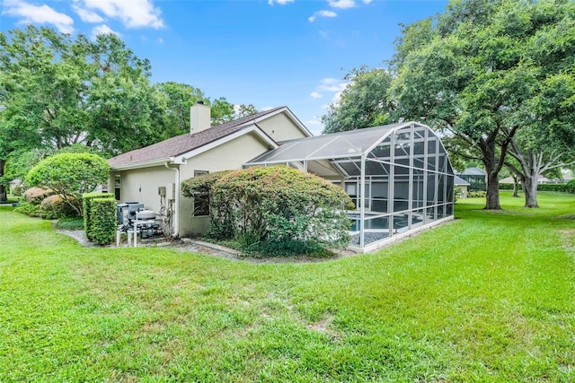 871 Paddington Ter, Lake Mary, FL 32746 - back of house with stucco siding, a yard, a chimney, and a lanai