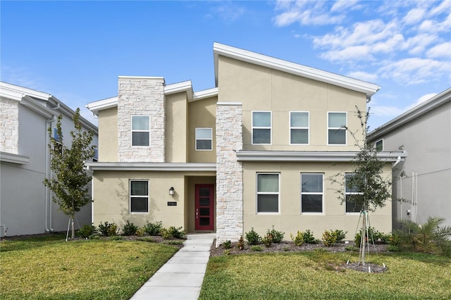 4185 Paragraph Dr, Kissimmee, FL 34746 - view of front of property with stucco siding, a front yard, and stone siding