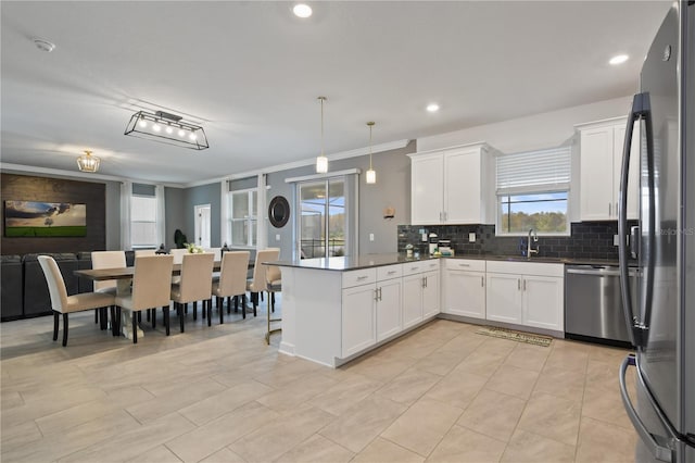 4185 Paragraph Dr, Kissimmee, FL 34746 - kitchen with stainless steel appliances, a peninsula, decorative backsplash, ornamental molding, and dark countertops