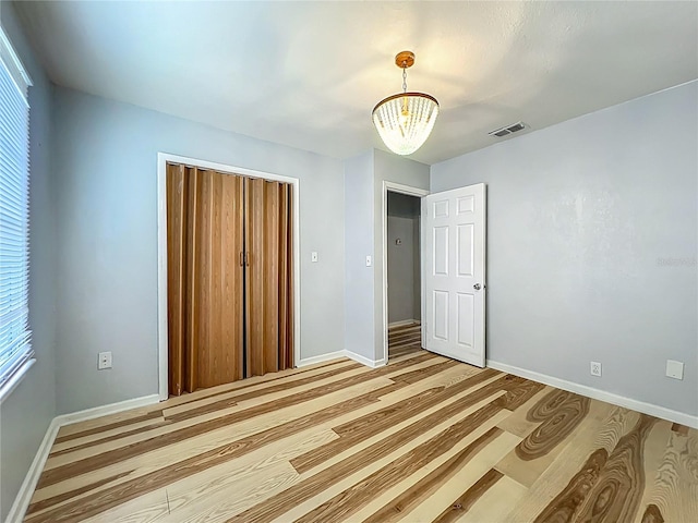 207 Kay St, Auburndale, FL 33823 - unfurnished bedroom with a chandelier, a closet, and light wood finished floors