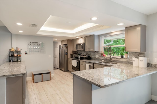 209 Carriage Hill Dr, Casselberry, FL 32707 - kitchen featuring stainless steel appliances, gray cabinetry, a peninsula, light stone counters, and recessed lighting