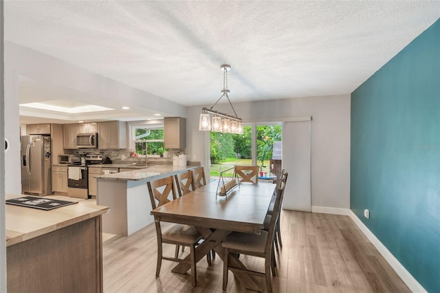 209 Carriage Hill Dr, Casselberry, FL 32707 - dining room with light wood finished floors and a textured ceiling