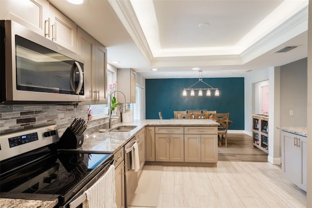 209 Carriage Hill Dr, Casselberry, FL 32707 - kitchen featuring stainless steel appliances, a peninsula, a raised ceiling, light stone countertops, and backsplash