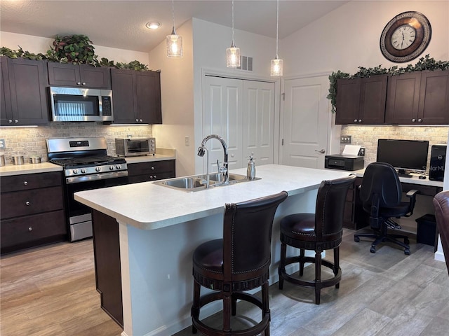 3328 Davis Ter, The Villages, FL 32163 - kitchen featuring stainless steel appliances, vaulted ceiling, light countertops, a kitchen breakfast bar, and decorative backsplash