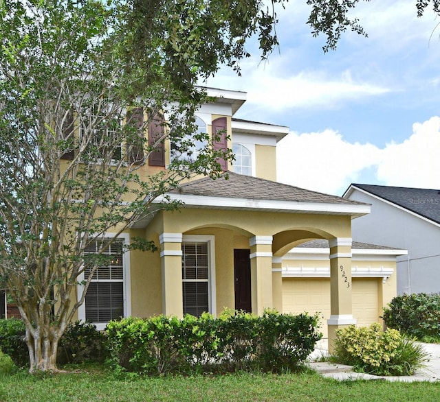 9223 Leeland Archer Blvd, Orlando, FL 32836 - view of front of home with stucco siding, an attached garage, and roof with shingles