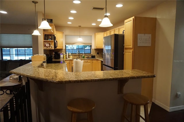 13785 SE 39th Ter, Summerfield, FL 34491 - kitchen with freestanding refrigerator, decorative backsplash, a peninsula, healthy amount of natural light, and recessed lighting