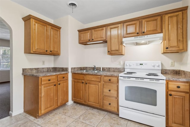 146 Mills Rd, Deland, FL 32724 - kitchen with white electric range, under cabinet range hood, arched walkways, brown cabinetry, and dark countertops