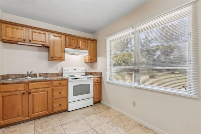 146 Mills Rd, Deland, FL 32724 - kitchen with white electric range, under cabinet range hood, brown cabinetry, light tile patterned floors, and dark countertops