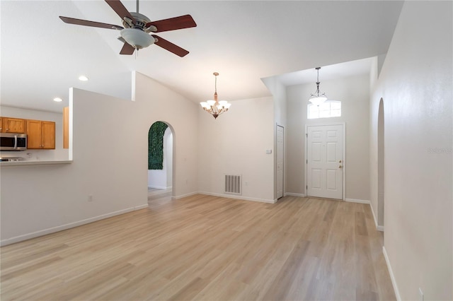 16603 Corner Lake Dr, Orlando, FL 32820 - unfurnished living room featuring arched walkways, a chandelier, light wood-type flooring, lofted ceiling, and a ceiling fan
