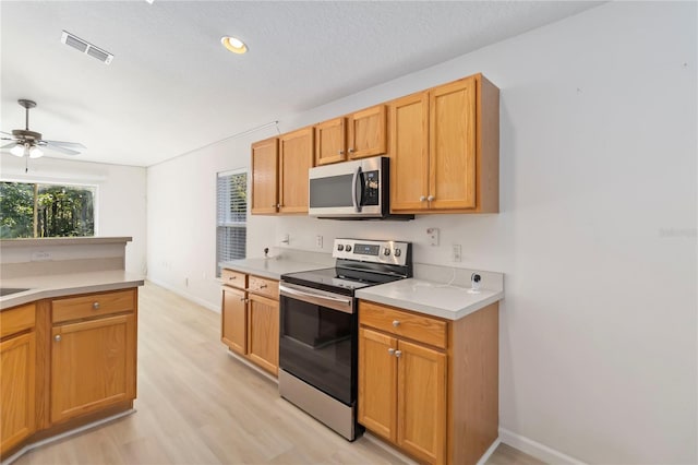 16603 Corner Lake Dr, Orlando, FL 32820 - kitchen featuring appliances with stainless steel finishes, ceiling fan, light wood finished floors, light countertops, and recessed lighting