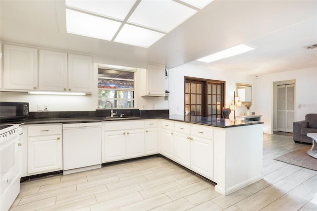1029 Antelope Trl, Winter Springs, FL 32708 - kitchen featuring white appliances, a peninsula, open floor plan, dark countertops, and white cabinetry