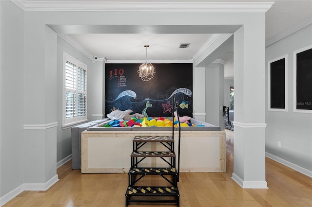 207 Via Tuscany Loop, Lake Mary, FL 32746 - bedroom featuring light wood-style flooring, a chandelier, and ornamental molding
