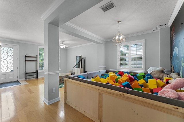 207 Via Tuscany Loop, Lake Mary, FL 32746 - playroom featuring plenty of natural light, light wood-type flooring, a textured ceiling, a chandelier, and ornamental molding