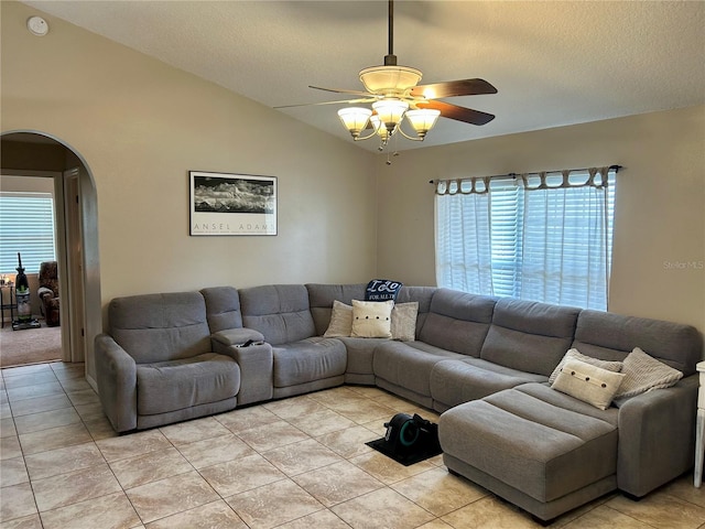 734 La Costa St, Minneola, FL 34715 - living room featuring arched walkways, a ceiling fan, light tile patterned flooring, vaulted ceiling, and a textured ceiling