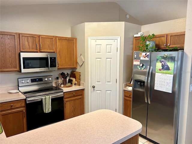 734 La Costa St, Minneola, FL 34715 - kitchen featuring appliances with stainless steel finishes, light countertops, brown cabinetry, and lofted ceiling