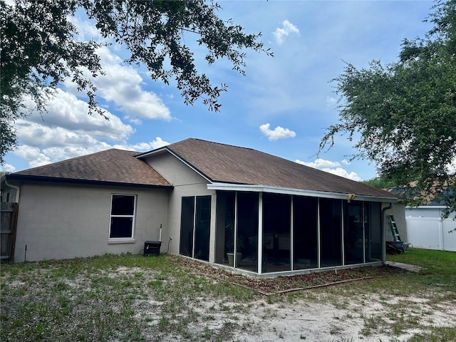 734 La Costa St, Minneola, FL 34715 - back of property featuring roof with shingles, a sunroom, and stucco siding