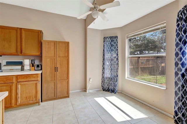 1039 Eagles Forrest Dr, Apopka, FL 32712 - kitchen featuring light countertops, a ceiling fan, light tile patterned floors, and brown cabinets