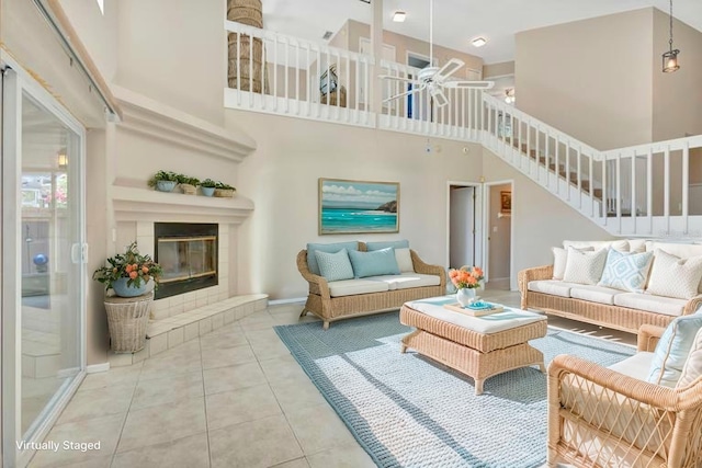 1039 Eagles Forrest Dr, Apopka, FL 32712 - living area featuring a high ceiling, stairway, ceiling fan, a tiled fireplace, and tile patterned floors