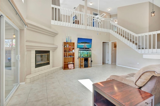 1039 Eagles Forrest Dr, Apopka, FL 32712 - tiled living area featuring a high ceiling, a ceiling fan, a tiled fireplace, and stairs