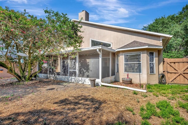 1039 Eagles Forrest Dr, Apopka, FL 32712 - back of house featuring a sunroom, a chimney, a gate, and stucco siding