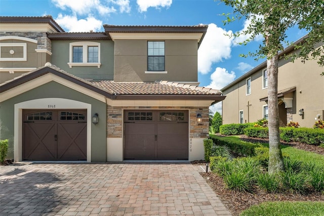 8970 Azalea Sands Ln Unit 2302, Davenport, FL 33896 - view of front facade with a tile roof, stucco siding, a garage, stone siding, and decorative driveway