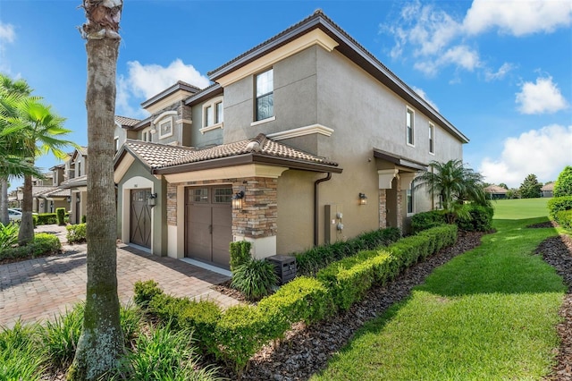 8970 Azalea Sands Ln Unit 2302, Davenport, FL 33896 - view of front facade featuring stucco siding, a front lawn, a tile roof, stone siding, and driveway
