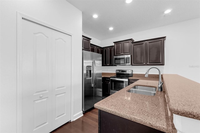 8970 Azalea Sands Ln Unit 2302, Davenport, FL 33896 - kitchen with appliances with stainless steel finishes, recessed lighting, dark brown cabinetry, dark wood-type flooring, and light stone countertops